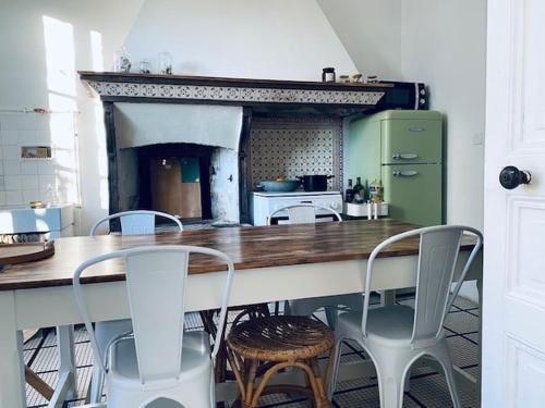 a kitchen with a table and chairs and a fireplace at Villa Constantine a 2 pas du port de Boyardville in Saint-Georges-dʼOléron