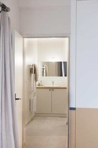 a bathroom with a sink and a mirror at L Hirondelle et l Instant in Dolus d'Oléron