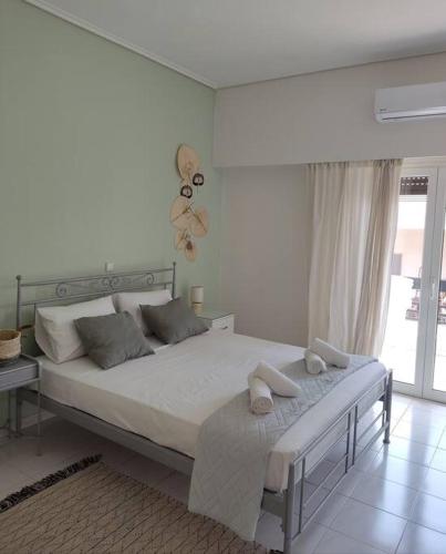 um quarto branco com uma cama grande e uma janela em M.V Apartment em Atenas