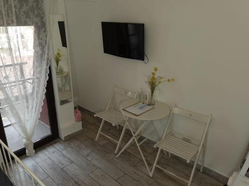 a room with a table and two chairs and a television at Stay In Tmisoara in Timişoara