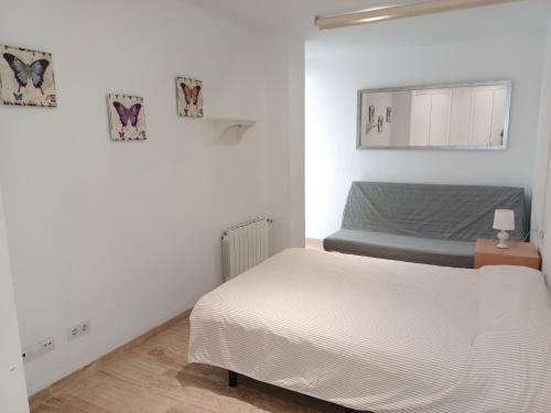 - une chambre blanche avec un lit et un miroir dans l'établissement Luxueux Appartement, à Alicante
