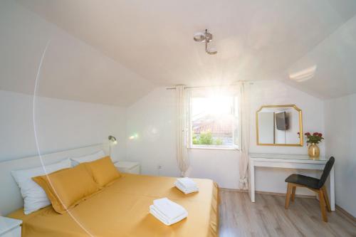 a small bedroom with a yellow bed and a window at Magnolia Apartments, Dubrovnik in Dubrovnik