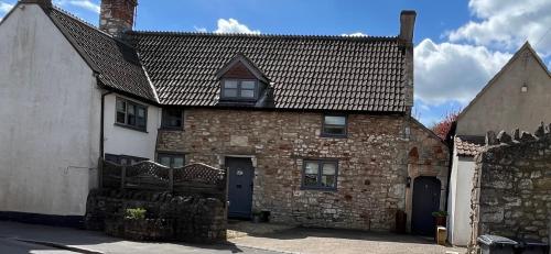 an old brick house with a black roof at The Old Farmhouse in Bristol