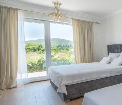 Un dormitorio con una cama y una ventana grande en Tiny guest house in peaceful part of Međugorje, en Međugorje