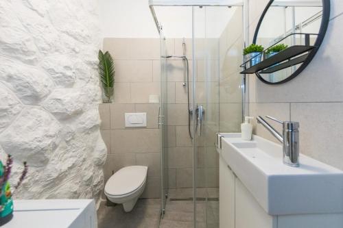 a bathroom with a shower and a toilet and a sink at Piccola apartments - 50m from beach in Dubrovnik