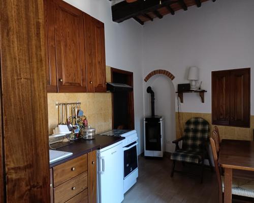 cocina con electrodomésticos blancos y mesa con silla en Ànita holiday house, en Montemerano