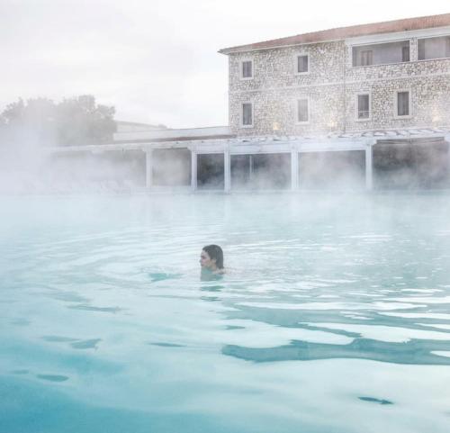una mujer nadando en un cuerpo de agua en Ànita holiday house, en Montemerano