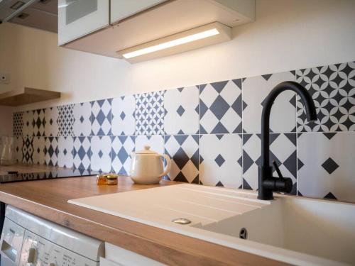 - une cuisine avec un évier, un canapé et un comptoir dans l'établissement Appartement tout équipé terrasse parking privatif, à Six-Fours-les-Plages