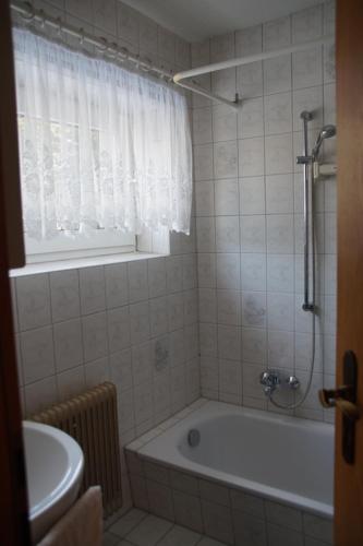 ein Bad mit einer Badewanne, einem Waschbecken und einem Fenster in der Unterkunft Holiday Home Martina in Dresden