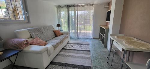 a living room with a white couch and a window at Les Pierres de Cézaire in Saint-Cézaire-sur-Siagne