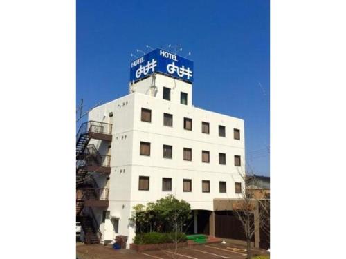 ein weißes Gebäude mit einem blauen Schild darüber in der Unterkunft Hotel Marui - Vacation STAY 14596v in Shibata