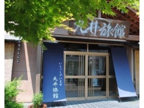 ein Gebäude mit einer blauen Tür und einem Schild darauf in der Unterkunft Hotel Marui - Vacation STAY 14596v in Shibata