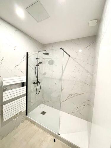 une salle de bain avec une douche avec une porte vitrée dans l'établissement Appartement moderne + Parking à 50m de la mer, à La Ciotat
