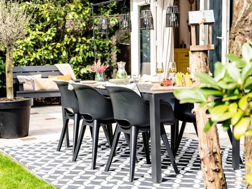a dining table and chairs on a patio at Stayatsas Tiny House Julia in de bossen op de Veluwe! in Epe