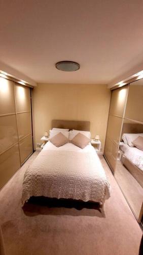 a bedroom with a large bed and two mirrors at Spacious 2 bedroom flat in Baker street in London