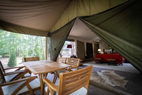 a tent with a wooden table and chairs in it at Pine Mountain RV Resort in Pine Mountain