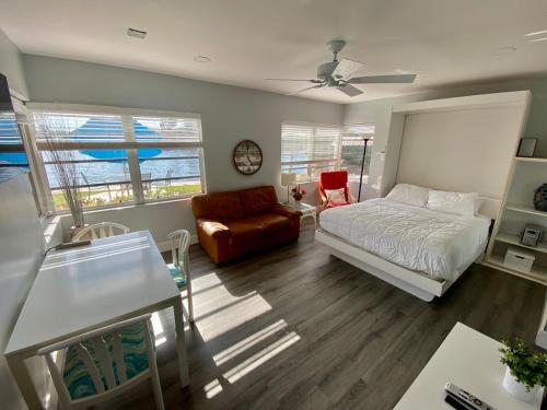 een slaapkamer met een bed, een bank en een tafel bij Studio Intracoastal Views! 5 Min Walk To The Beach in Pompano Beach