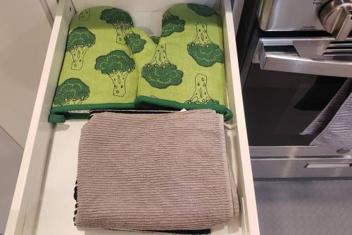 einen offenen Kühlschrank mit grünem Handtuch und Brokkoli in der Unterkunft Cozy 2 Bedroom Suite, Queen Beds, Near the Airport in Edmonton