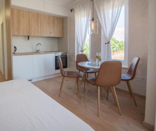 メジュゴリエにあるTiny guest house in peaceful part of Međugorjeのテーブルと椅子のあるキッチンとダイニングルーム