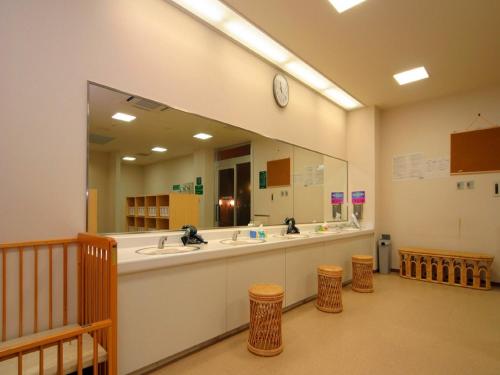 baño con 2 lavabos y espejo grande en Japanese Auberge Plaza Ryokufu Natural Hot Spring - Vacation STAY 03215v, en Shimo-orube