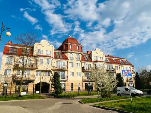 een groot bruin gebouw met een rood dak bij Apartament Villa Park in Ełk