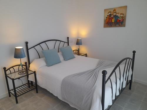 a bedroom with a large white bed with blue pillows at Casa Rosa in Olhão