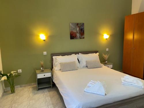 a bedroom with a bed with white sheets and two lights at Villa Agathi in Roda