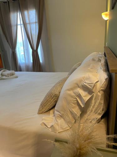 a white bed with a pillow and a window at Villa Agathi in Roda