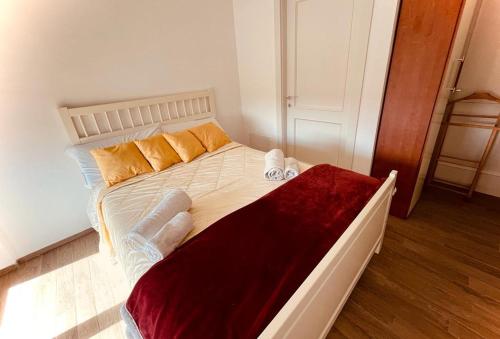 a bedroom with a large white bed with orange pillows at Fiera&Aeroporto House in Fiumicino
