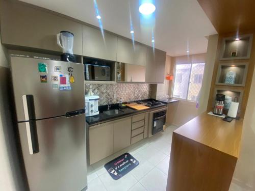 a kitchen with a stainless steel refrigerator and a counter at Apartamento Ideal Flores in Manaus