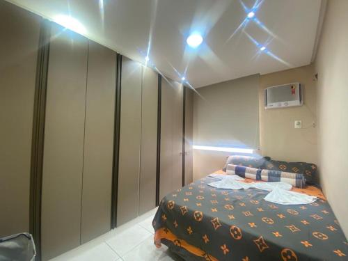 - une chambre avec un lit et des lumières au plafond dans l'établissement Apartamento Ideal Flores, à Manaus