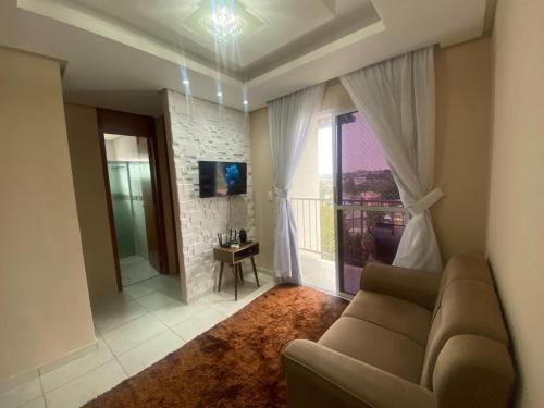 a living room with a couch and a large window at Apartamento Ideal Flores in Manaus