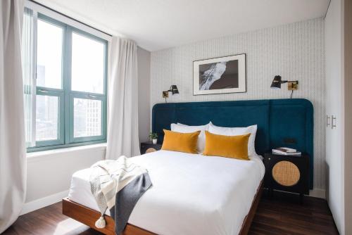 um quarto com uma cama grande e almofadas amarelas em Kasa Magnificent Mile Chicago em Chicago