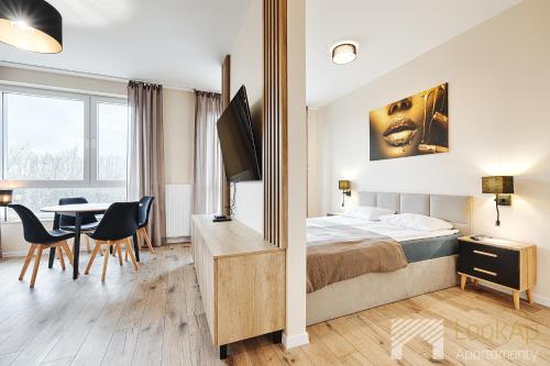 a hotel room with a bed and a table and chairs at Manu Park I by LookAp Parking Gratis in Łódź