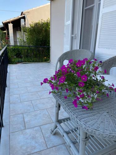 a wicker chair with purple flowers on a patio at Villa Agathi in Roda