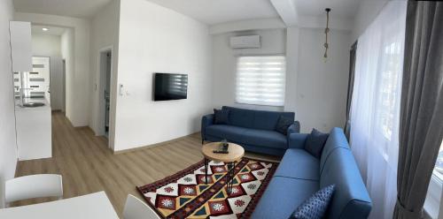 a living room with a blue couch and a table at Apartmani Art in Jajce