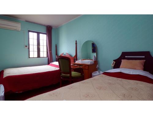 1 dormitorio con 2 camas, escritorio y silla en Nikko Park Lodge - Vacation STAY 15302v en Nikko