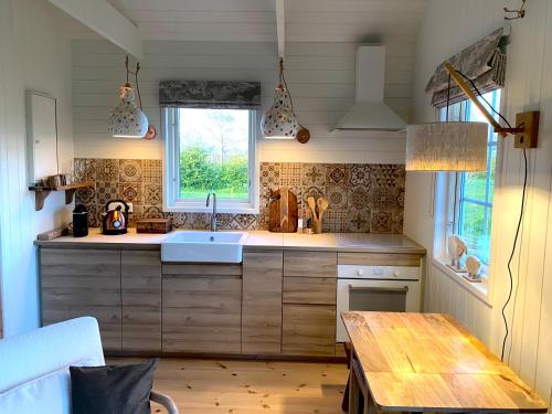 a kitchen with a sink and a wooden table at De Heeren Hoeve Carpe Diem in Heijen