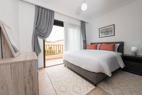 a bedroom with a bed and a large window at Villa 10 Palmeraie Golf Agadir in Agadir