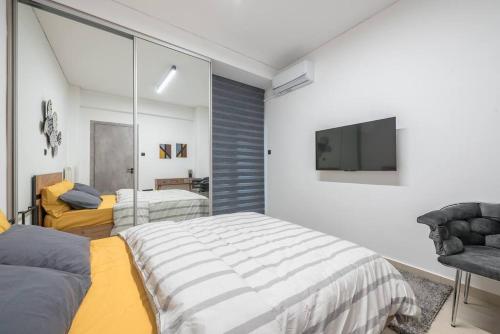 um quarto com uma cama grande e uma televisão em Ano Patisia Station Studio em Atenas