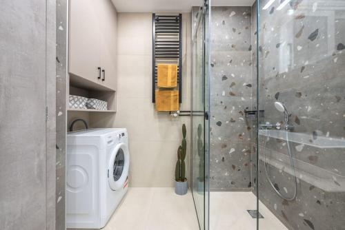 a bathroom with a shower and a washing machine at Ano Patisia Station Studio in Athens