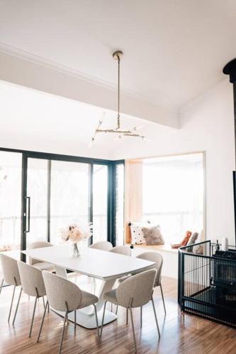 a white dining room with a white table and chairs at Suyapto House in Hahndorf