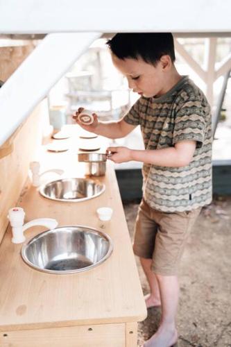 a young boy standing in front of a sink at Suyapto House in Hahndorf