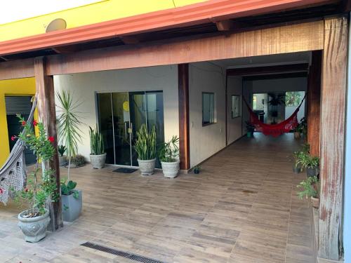 eine leere Terrasse mit Topfpflanzen an einem Gebäude in der Unterkunft Casa Grande Hostel in Brumadinho