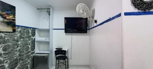 a room with a wall with a tv and a stool at Casa Hotel Manco Mora in Medellín