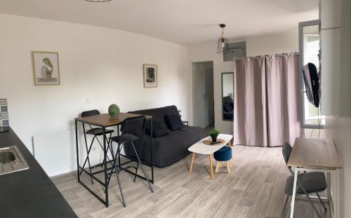 ein Wohnzimmer mit einem Sofa und einem Tisch in der Unterkunft 99 BIS FP in Limoges