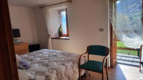 una camera con un letto e una sedia e una finestra di Casa Indipendente Val d'Ayas - Challand Saint Anselme a Challand Saint Anselme