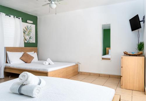 um quarto de hotel com duas camas e uma televisão em Casamares Private Room Arena with Pool and Jacuzzi 5 min to Boqueron and Beaches em Cabo Rojo