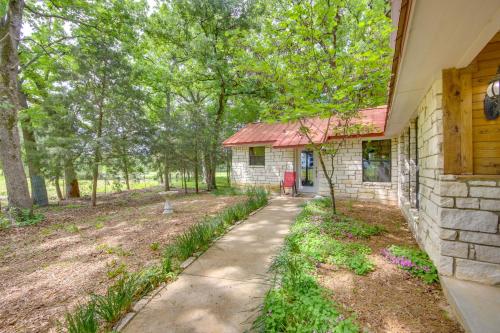 a stone house with a red roof and a sidewalk at Dog-Friendly Wills Point Home with Grill on 10 Acres in Canton
