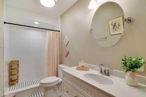 ein Badezimmer mit Waschbecken, Toilette und Spiegel in der Unterkunft Dock and Fire Pit Lakefront Poconos Retreat! in Long Pond